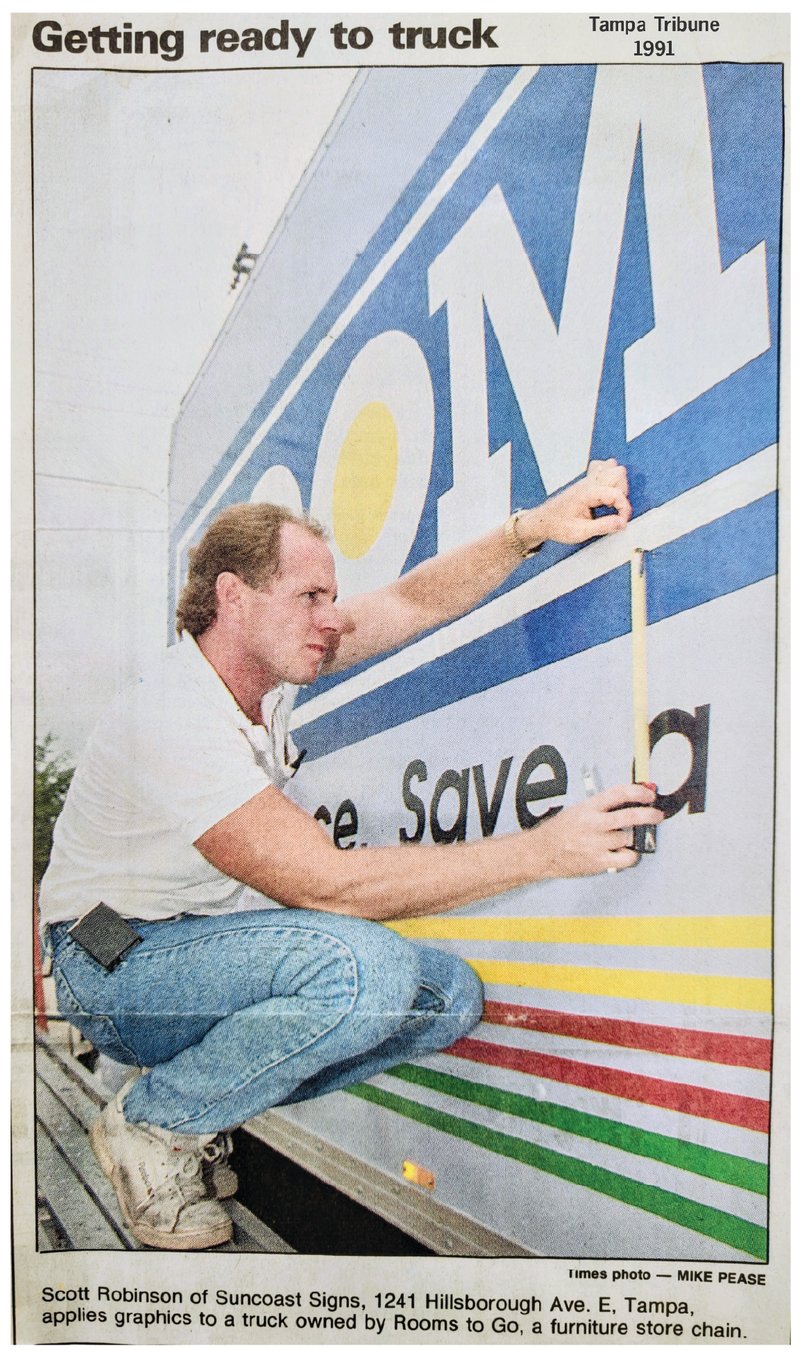 Tampa Tribune 1991 — Scott Robinson of Suncoast Signs applies graphics to a Rooms to Go truck